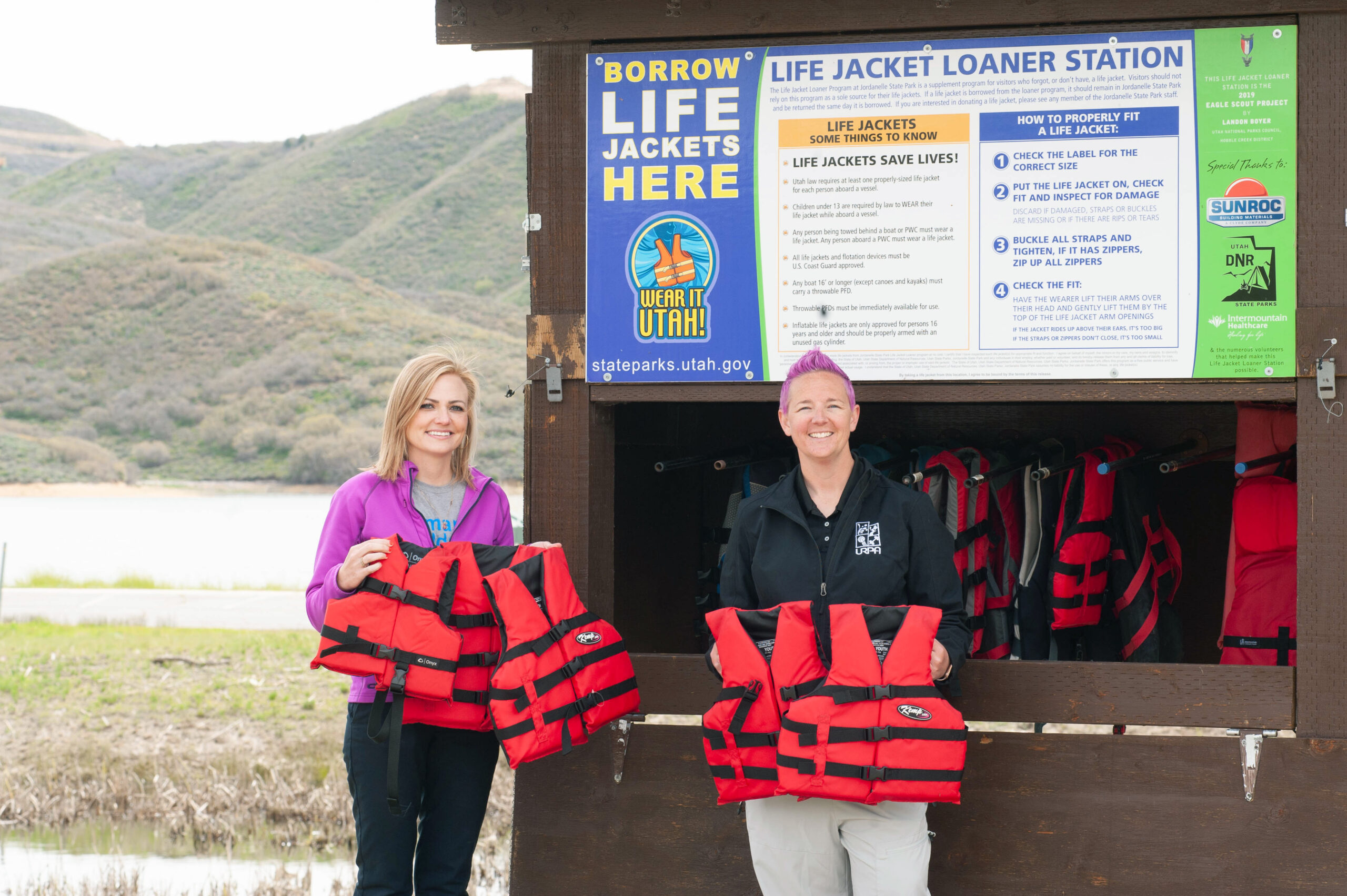 Karlee Kump, community health manager at Intermountain Primary Children's Hospital (left) with McKell Christensen of the Utah Drowning Prevention Coalition. Jordanelle Life Jacket Loaner Station on May 24, 2024.