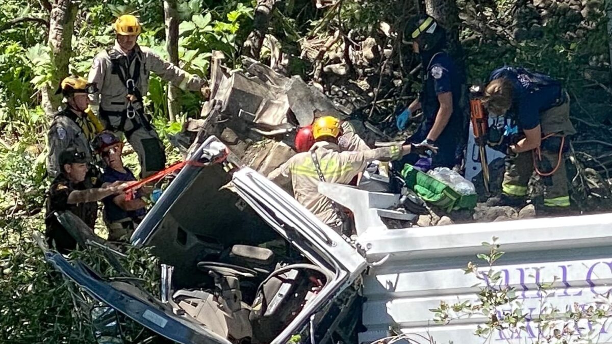 Rescue crews work to extricate the driver after a dump truck plummeted 200 feet into a ravine in Tollgate Canyon.