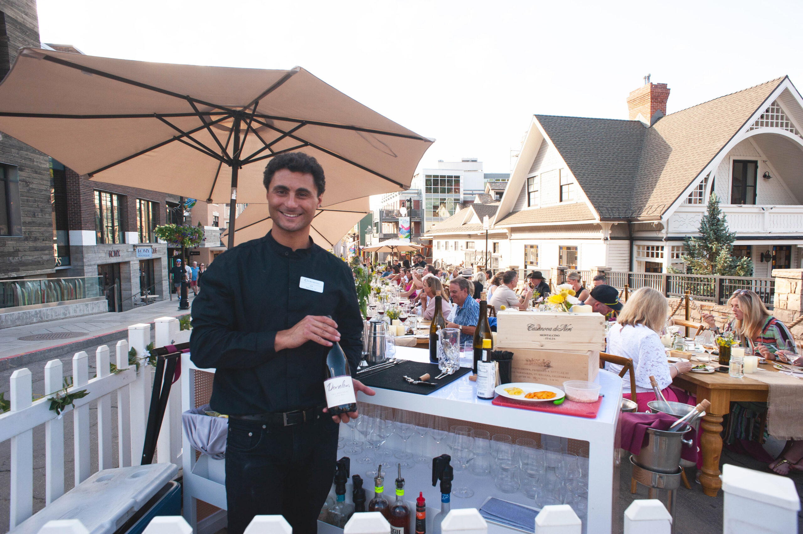 Courchevel's bartender shows a wine offering as the sun sets at Savor the Summit 2024 on Main Street in Park City.