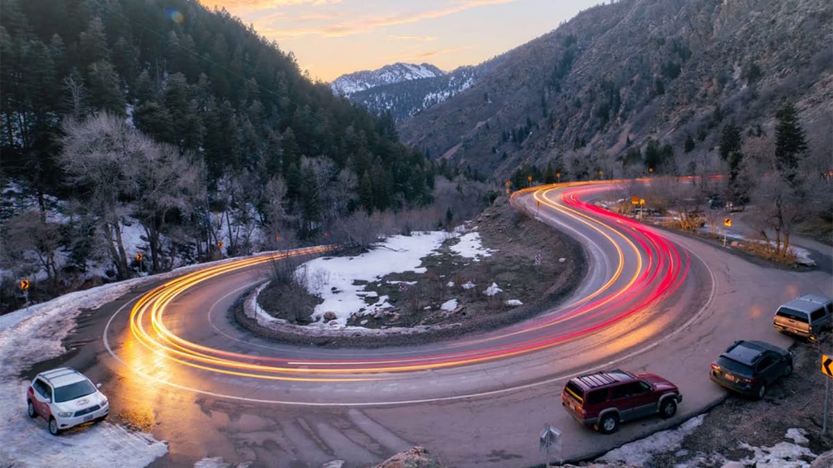 Car lights blur around an iconic curve in Big Cottonwood Canyon. A recent report shows the Wasatch Canyons get twice as many visitors annually as Arches National Park.