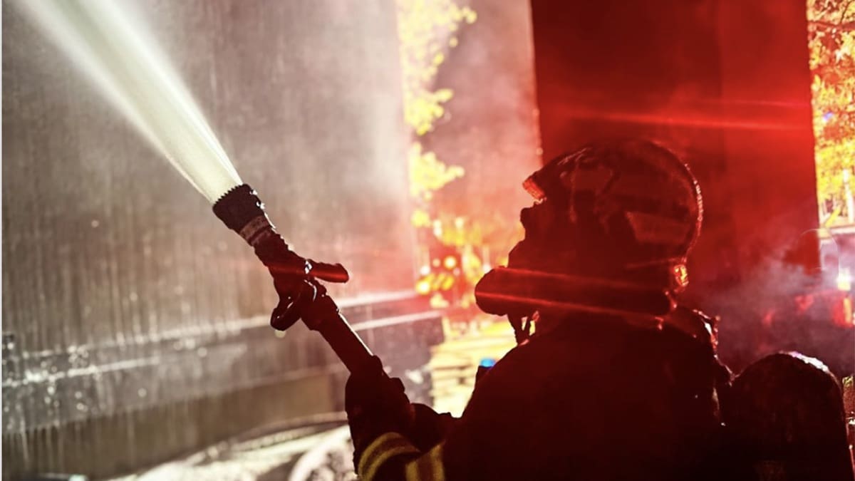 A Park City firefighter works to put out a fire at a Park City residence late Saturday night.