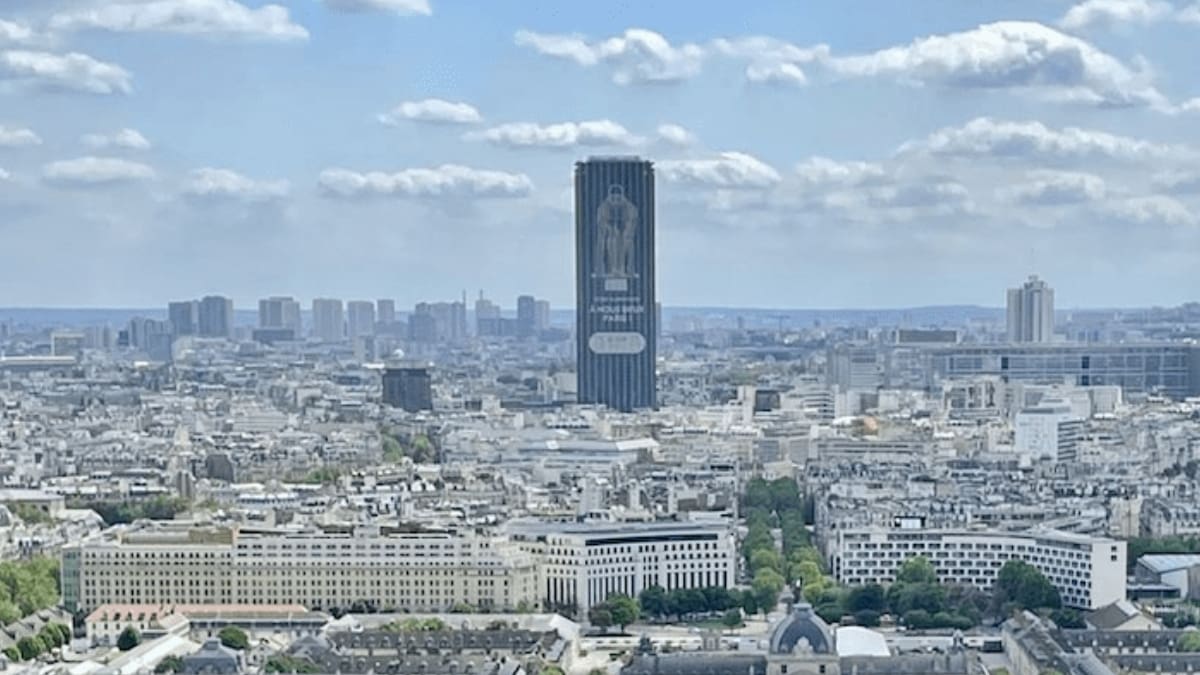 Showcasing the popular track events, Paris' tallest building, rectangular and black, is wrapped in the image of an Olympic runner like Utahn Rooks.