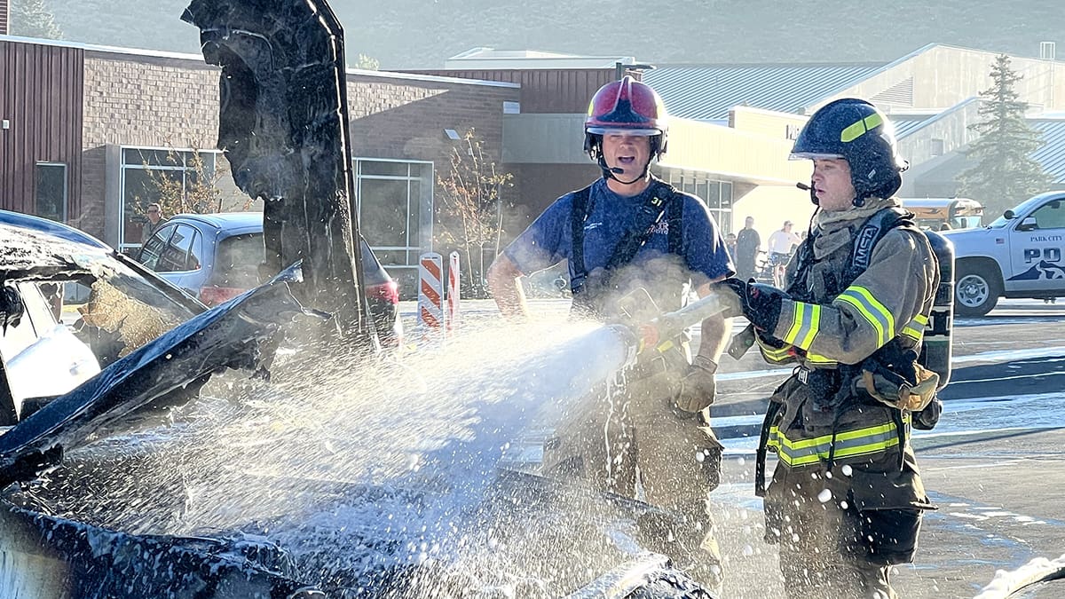 Firefighters extinguish a car fire in the parking lot of McPolin Elementary School on Friday, August 6, 2024.