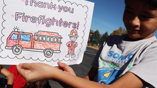 A Trailside Elementary student shows a picture colored for the Yellow Lake Firefighters.