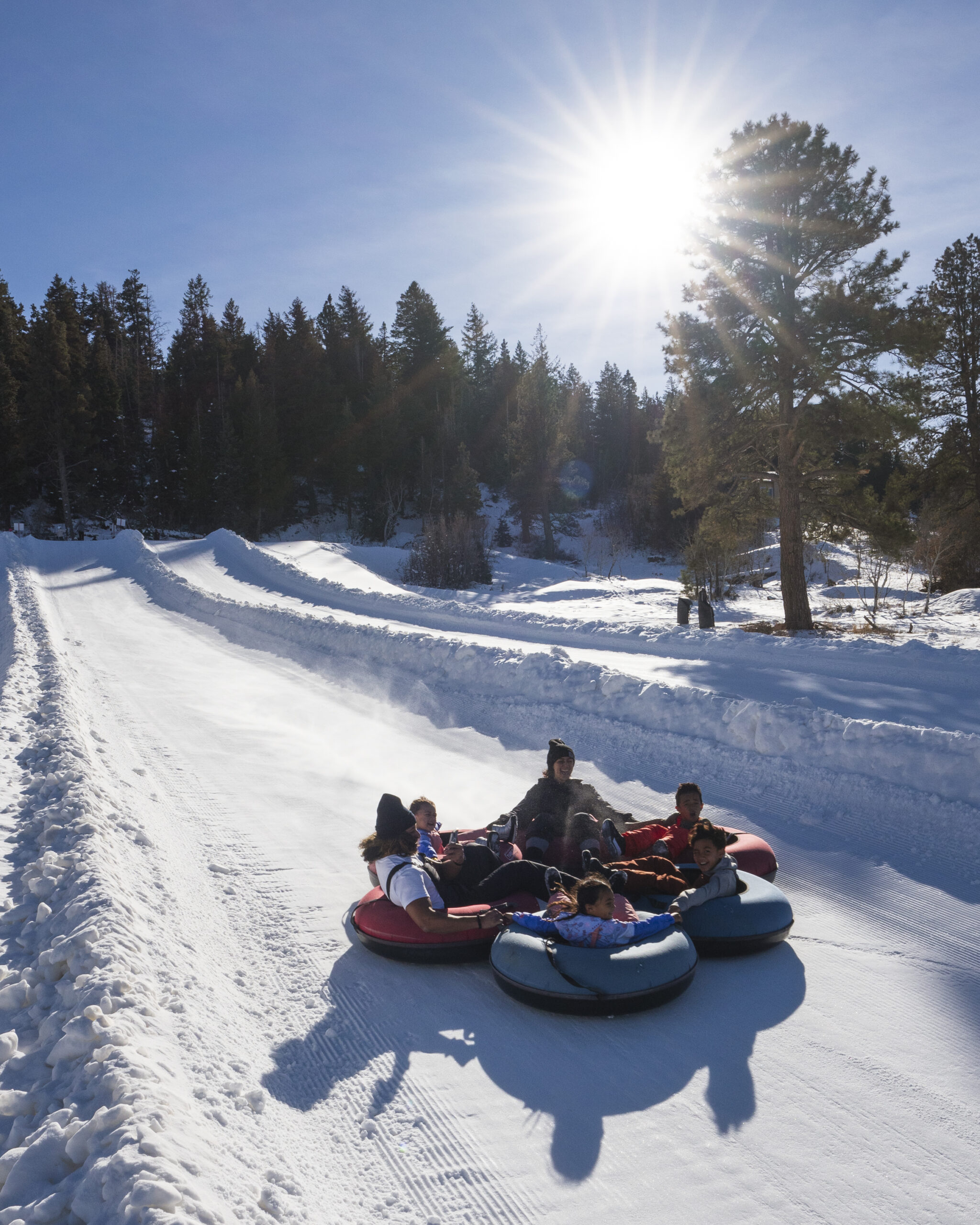 Three people enjoying winter tubing