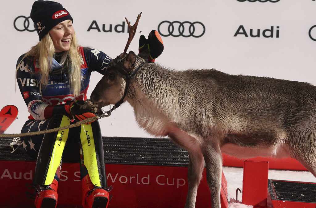 The winner United States' Mikaela Shiffrin makes friends with a baby reindeer as she waits for Santa on podium after an alpine ski, women's World Cup slalom, in Levi, Finland, Saturday, Nov. 16, 2024.