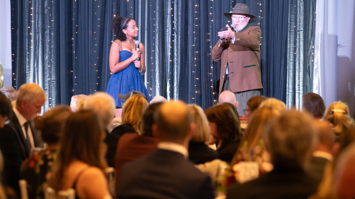 Tom Kelly, pictured here volunteering in October at Deer Valley Resort's Stein Eriksen Lodge on stage as the Master of Ceremonies of Jans Winter Welcome introducing a young figureskater.