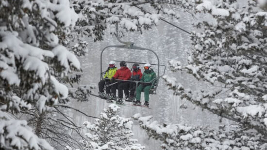 Skiers ride up through snowy trees at Deer Valley Resort.