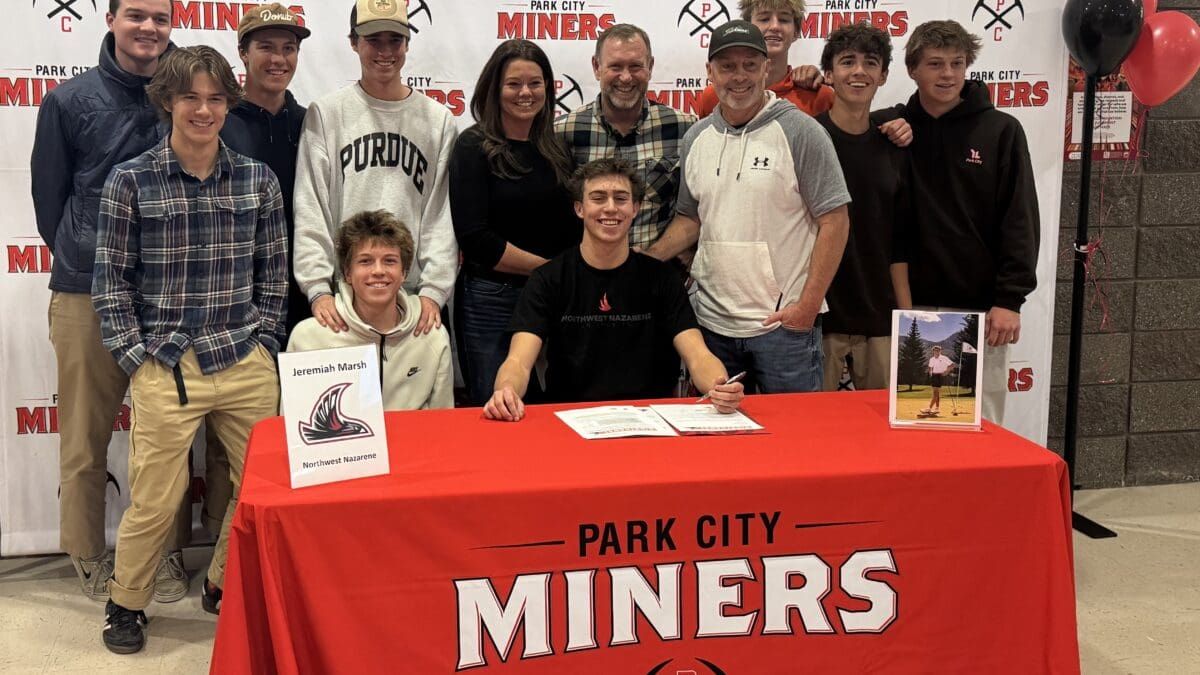 Jeremiah Marsh, his mom Casey, his dad Joel right behind him, and his golf coach at the Signing Ceremony held at the Park City High School surrounded by his friends.