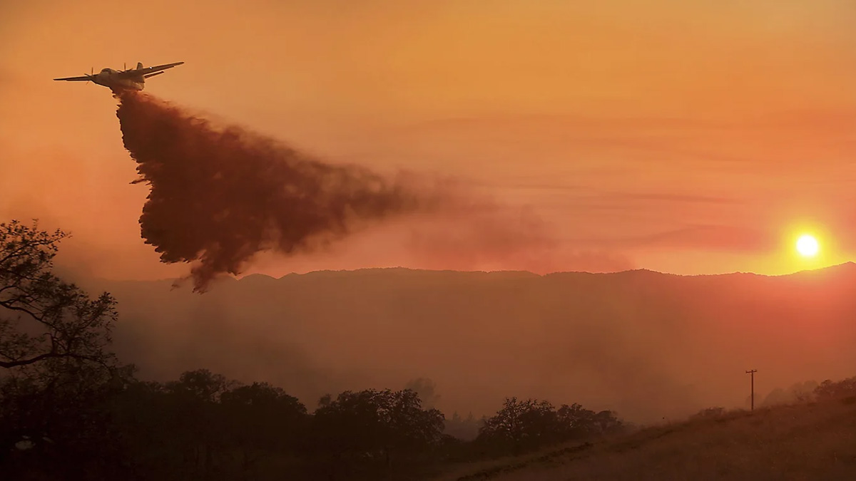 A Cal Fire tanker makes a drop on a wildfire at sunset on Thursday, Jan. 12, 2025.