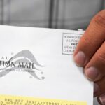 A election worker holds an election envelope during a tour of Utah County's elections equipment and review processes for administering secure elections, April 19, 2022, in Provo, Utah.
