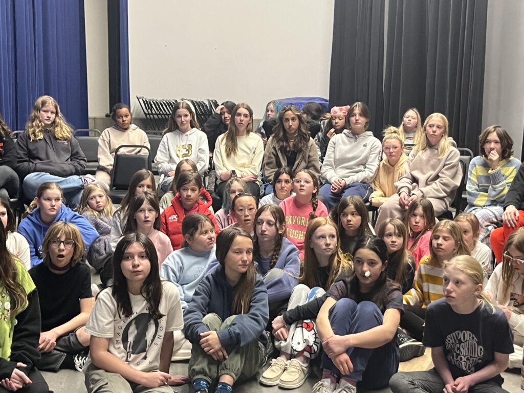 teenage girls of the Weilenmann School of Discovery listening to Lindsey Vonn via virtual appearance alongside ambassadors of her Foundation.