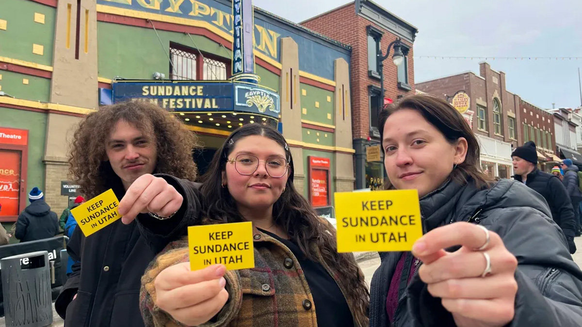 Attendees of the 2025 Sundance Film Festival hold up "Keep Sundance in Utah" stickers on Main Street in Park City, Utah, Friday, Jan. 24, 2025.