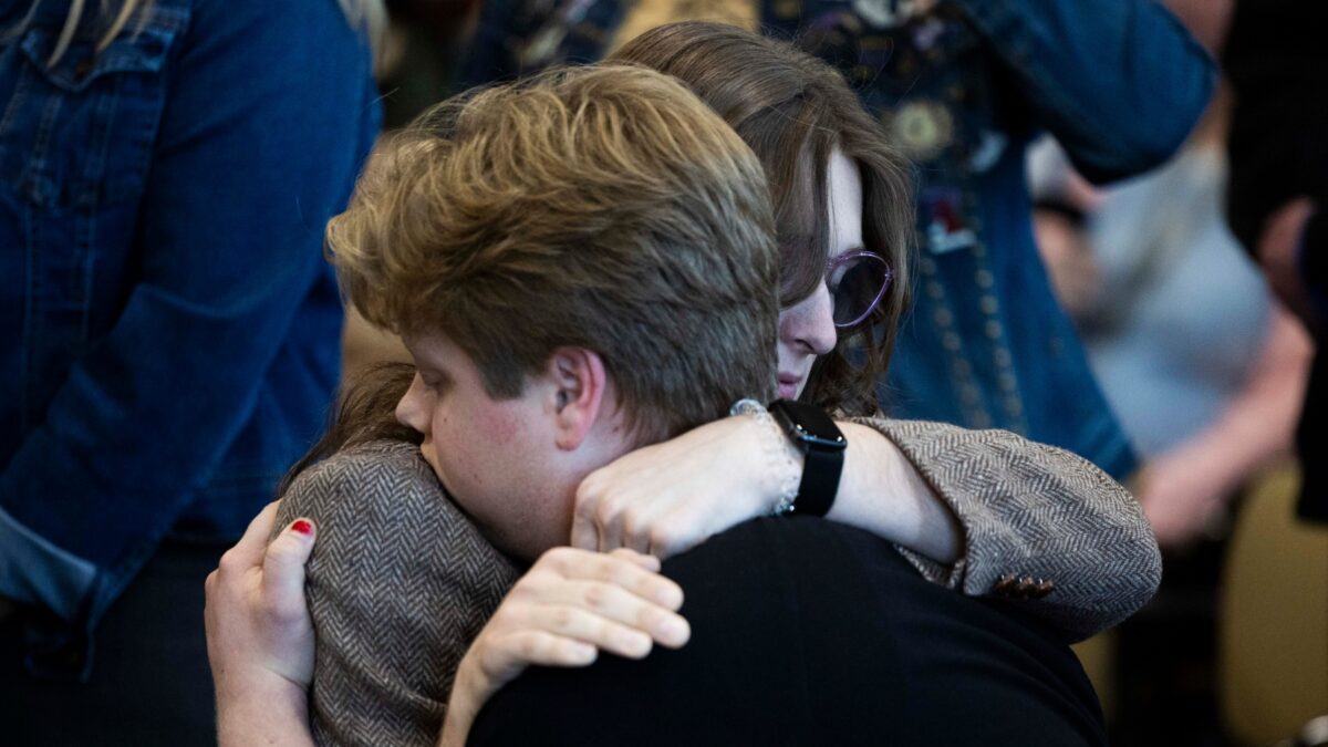 Marcie Robertson, a 20-year-old transgender Utah State University student and resident assistant, hugs her brother Ezra Robertson after speaking at a hearing on HB269, which pertains to privacy protections in sex-designated areas, in the Senate Education standing committee in Salt Lake City on Thursday, Jan. 30, 2025.