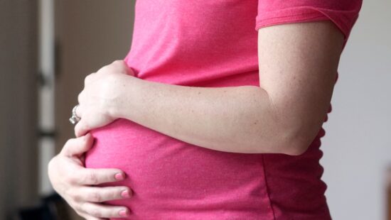 A pregnant woman stands for a portrait in Dallas, Thursday, May 18, 2023.