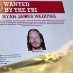 An image of former Canadian Olympic snowboarder Ryan Wedding, 43, who is a fugitive and charged with allegedly running and participating in a transnational drug trafficking operation, is displayed on a video monitor along with bricks of cocaine, foreground, during a news conference at the FBI offices in Los Angeles, Thursday, Oct. 17, 2024.