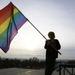 Corbin Aoyagi, a supporter of gay marriage, waves a rainbow flag during a rally at the Utah State Capitol on Jan. 28, 2014, in Salt Lake City.