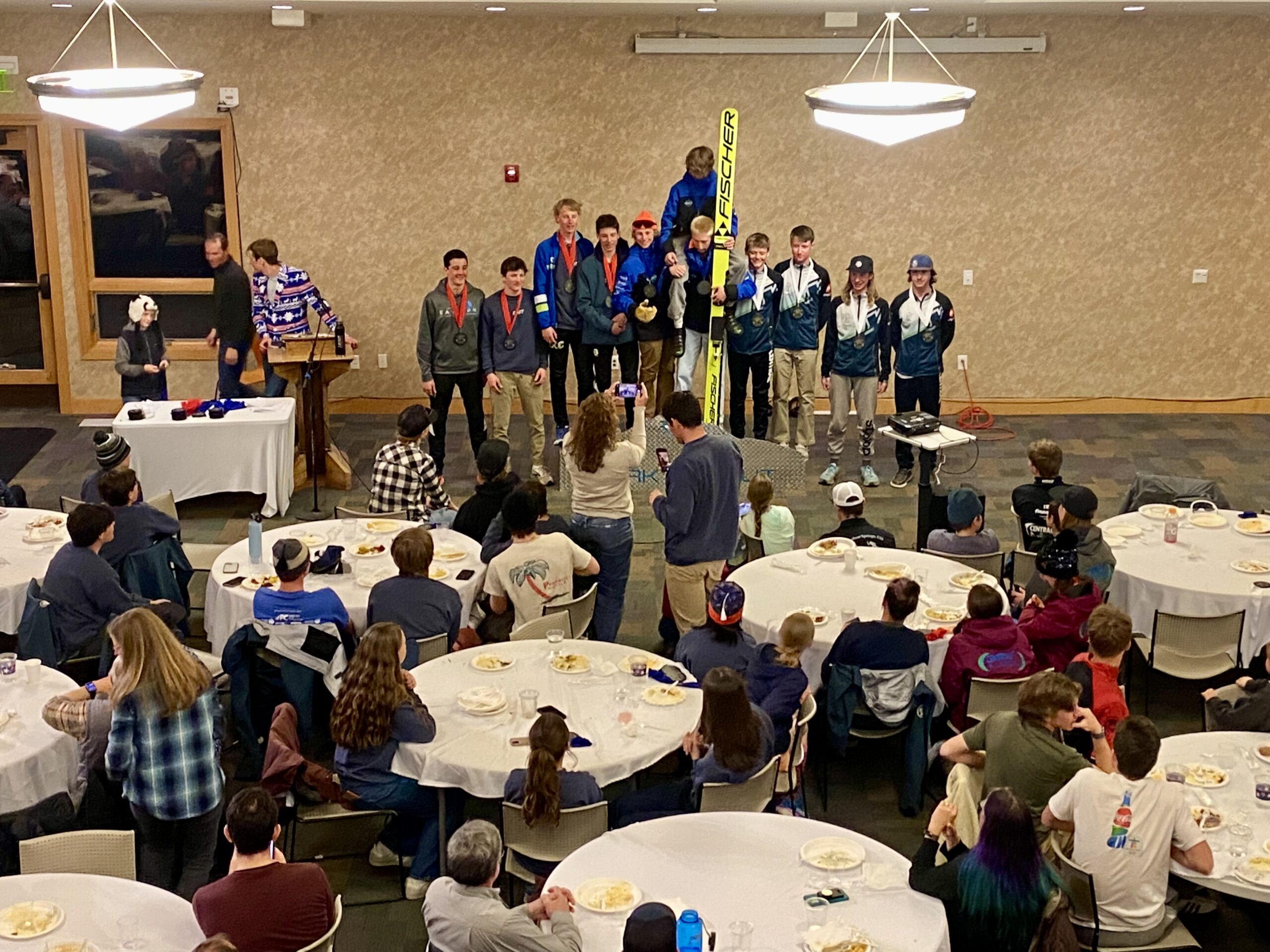 Awards Banquet with Park City's event organizer Adam Loomis in his signature, festive ski sport coat speaking to Olympic Champion Billy Demong.