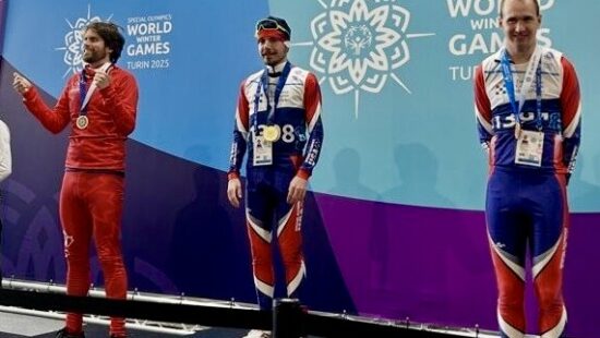 Hyrum Palmer, right, stands on the third-place podium in Italy for snowshoeing at the Winter Games.