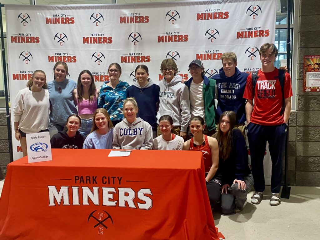 Senior Keeley Fisher, surrounded by her classmates and teammates signs to XC ski for Colby College.