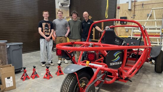Park City High School engineering students Brian Johnson, Jackson Carlson and Sean Kopish stand with teacher Brad Gannon beside the three-seat Switch Lab electric car they built this year in the PC CAPS lab.