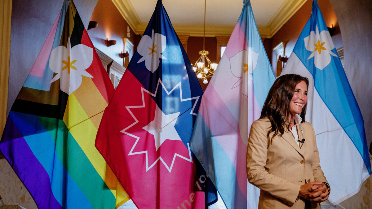 Salt Lake City Mayor Erin Mendenhall stands in a City Hall corridor Tuesday after the council vote, framed by (from left) the Sego Belonging, Sego Celebration, Sego Visibility and original Sego Lily flags—now all official city emblems ahead of Utah’s new flag-display law.