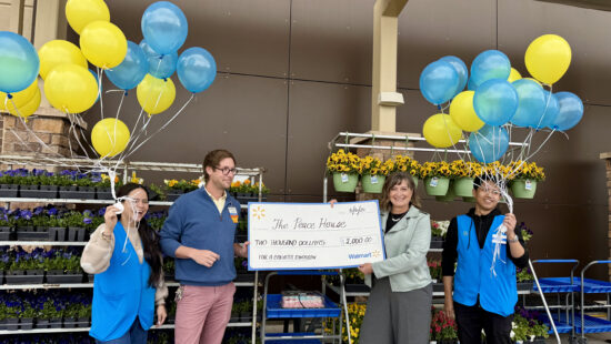 Peace House Executive Director Kendra Wyckoff, second from right, accepts a $2,000 grant check from Park City Walmart associates during a Mother’s Day–week donation event outside the store.