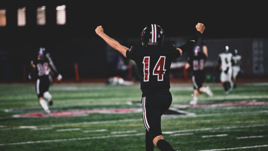 Park City senior Bash Bodily (#14) celebrates during a home game under the lights, part of a football program that has sent more than 30 players to college since 2020.