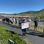 Protesters line the pedestrian overpass at Kimball Junction in Park City, Utah, on Saturday, June 14, 2025, as part of the national “No Kings” day of action.