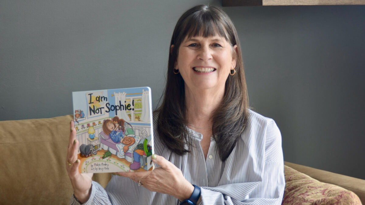 Robyn Hodess, Park City-based artist and author, holds her debut children’s board book I Am NOT Sophie!, a playful celebration of imagination and self-expression.
