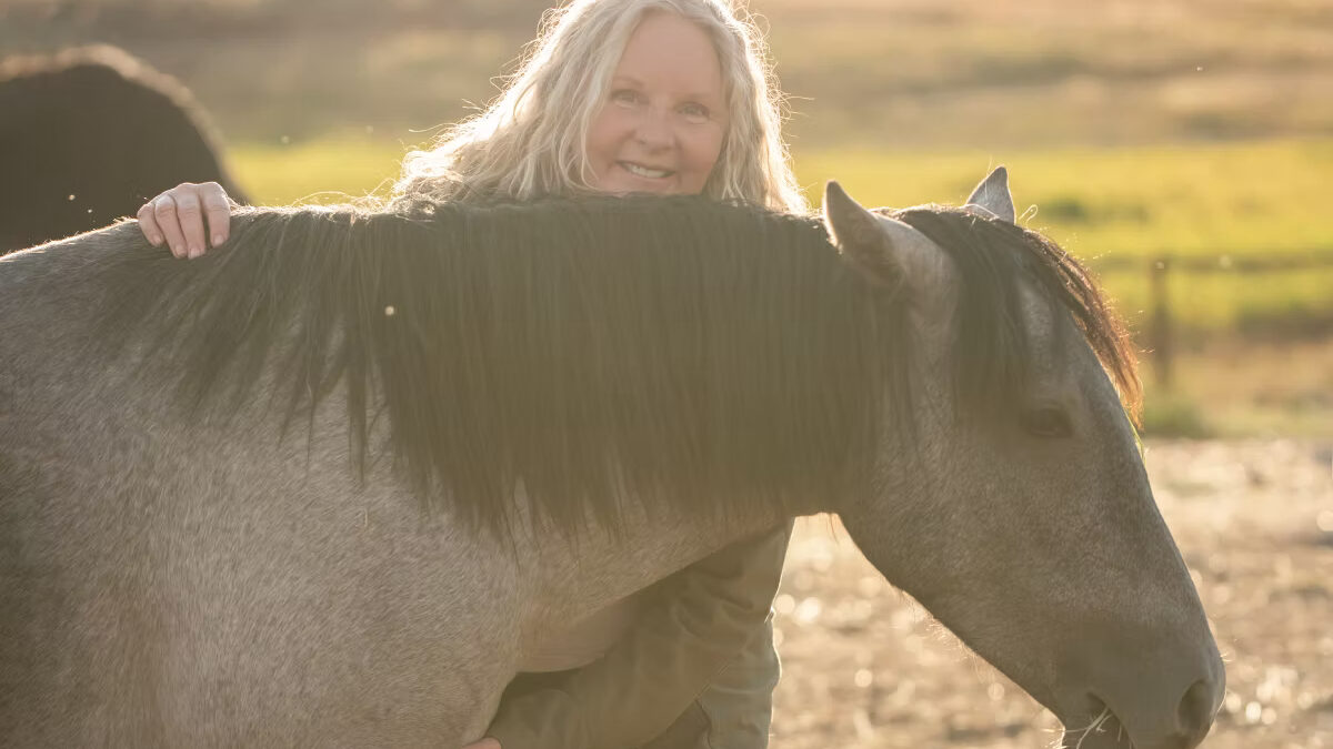 Sonya Richins, founder of Wild Heart Sanctuary, shares a quiet moment with one of the rescued mustangs on the sanctuary’s 20-acre Park City property.