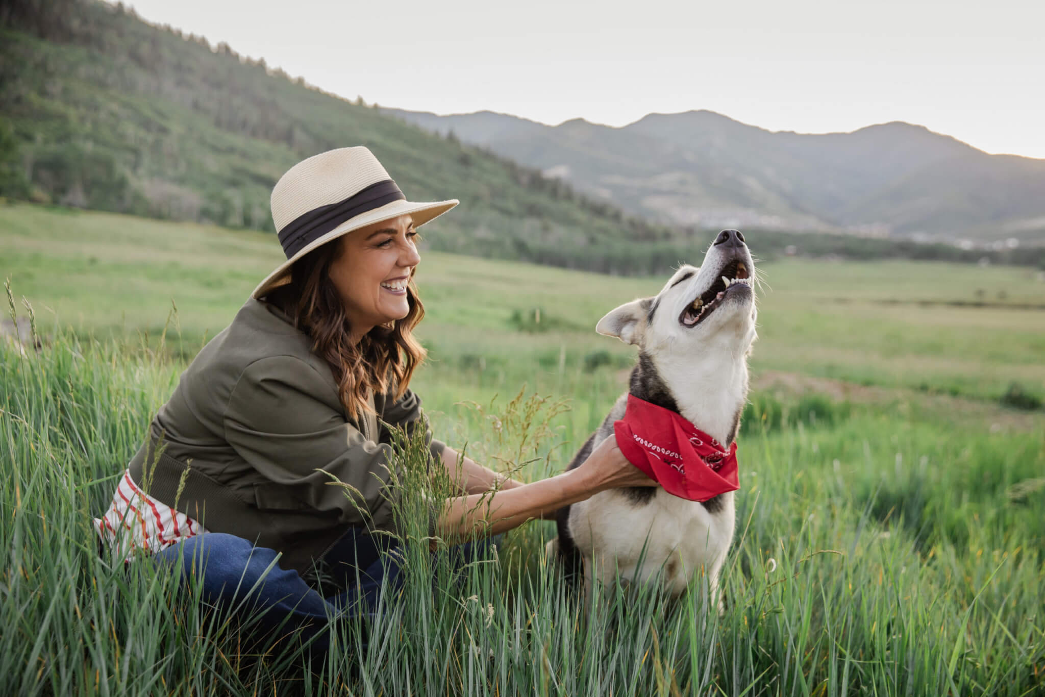 Caren Bell shares a joyful moment in the grass with her dog, reflecting the spirit of connection and community at the heart of the Kept Kind™ campaign.