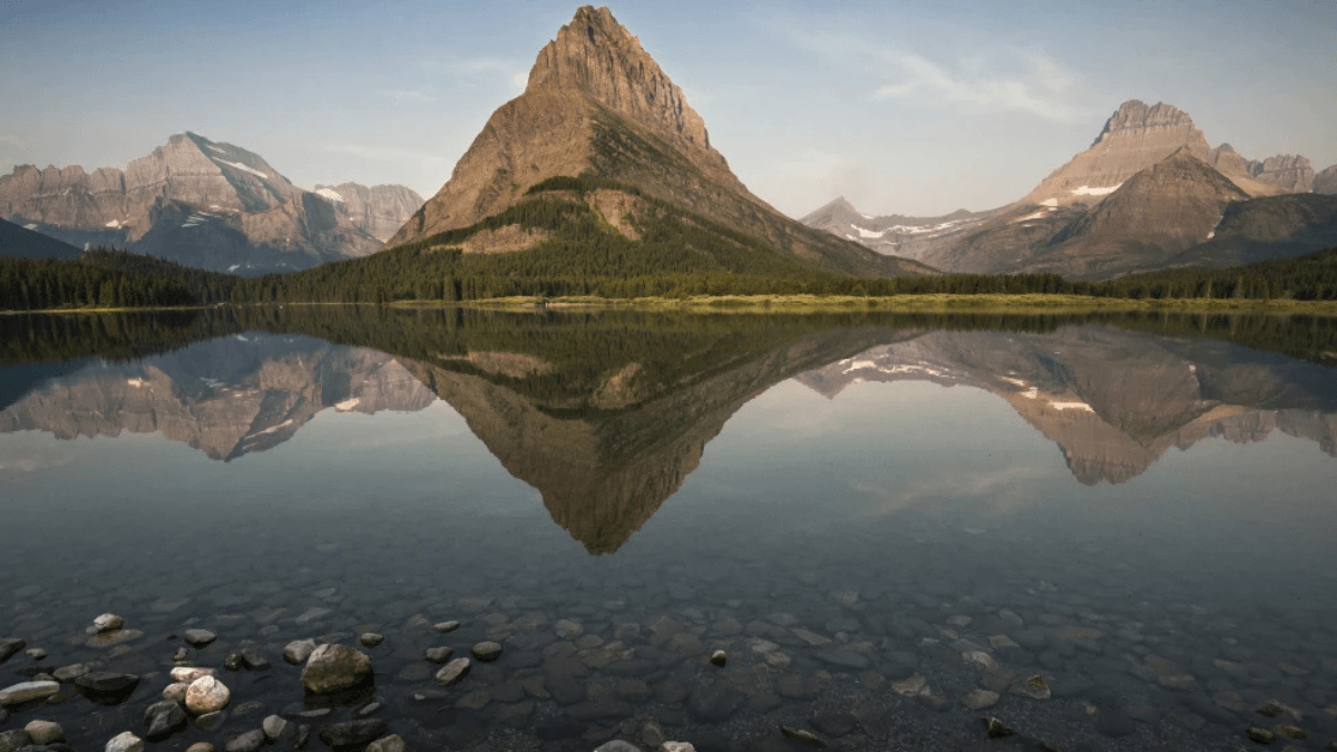 Grinnell Peak, flanked by Mount Gould to the left and Mount Wilbur to the right, is reflected on the surface of Swiftcurrent Lake at Glacier National Park near West Glacier, Montana, May 28, 2014.