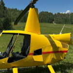 A privately owned helicopter sustained significant damage during the emergency landing, including a detached tail boom and rotor