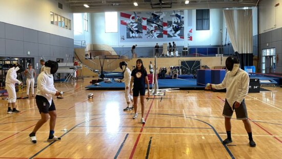 Olympic fencer Anne Cebula guides US ski team members through a fencing bout.