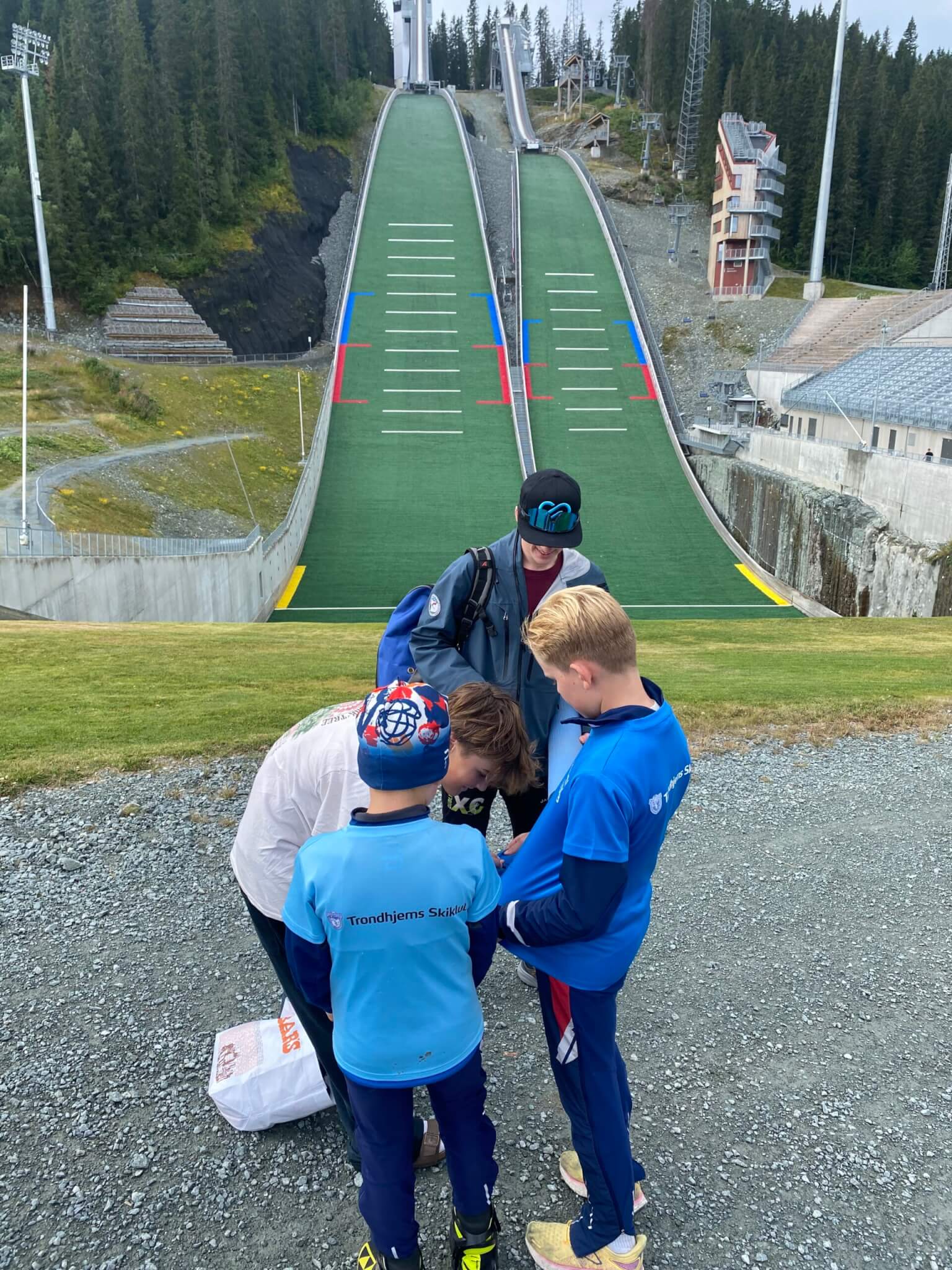 Liam Demong (white shirt) and another Nordic Combined athlete from the East Coast in Norway and fulfilling the request from local youth to sign their autographs as American athletes on their t-shirts.