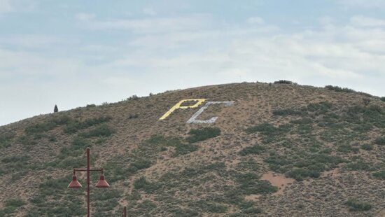 The iconic PC letters spray painted black and god.