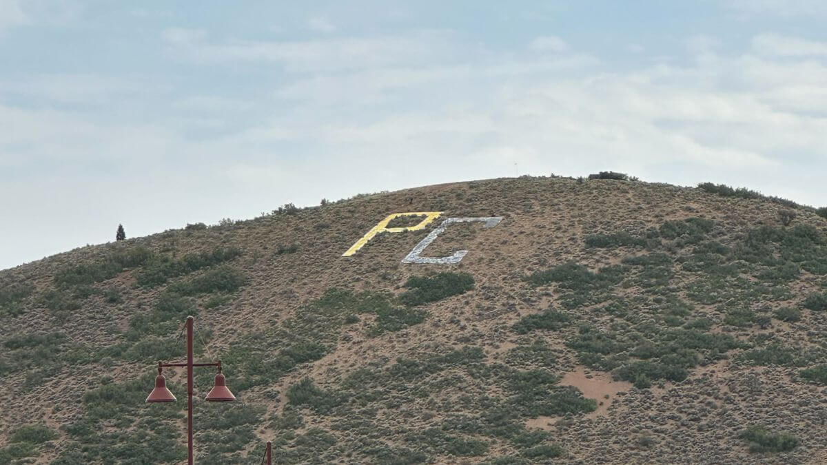 The iconic PC letters spray painted black and god.