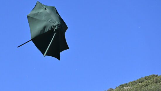 A patio umbrella is snapped as it flies through the air after a gust of wind lifted it near the Park City Library.