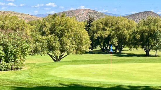 White PC of the Park City High School Miners Mountain seen in the background of their home field-of-play at the Park City Municipal Golf Course.