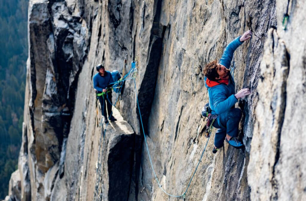 Climber Sonnie Trotter leads a pitch on a towering granite wall while a partner belays from a ledge. Trotter will present his new memoir, Uplifted: The Evolution of a Climbing Life, at Patagonia Salt Lake City on Oct. 1.