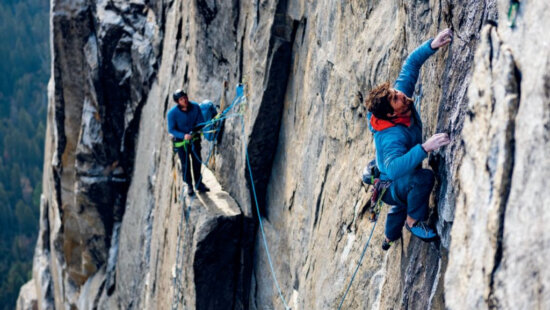 Climber Sonnie Trotter leads a pitch on a towering granite wall while a partner belays from a ledge. Trotter will present his new memoir, Uplifted: The Evolution of a Climbing Life, at Patagonia Salt Lake City on Oct. 1.