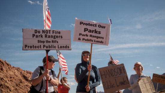 Former park ranger Allyson Mathis, left, and others protest the government shutdown outside the entrance to Arches National Park in Moab on Monday, Oct. 27, 2025.