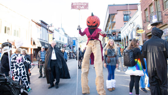 Costume clad Parkites stroll Main Street for a Halloween celebration in Park City.