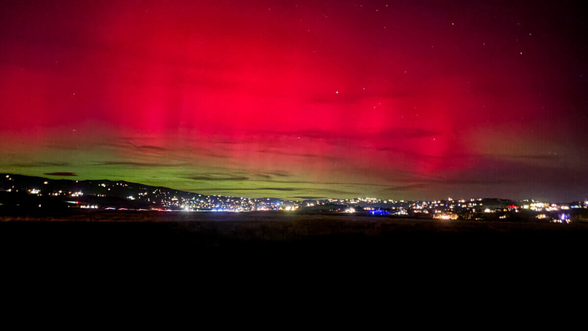 Aurora borealis glows above Park City’s skyline on November 11, casting vivid green and pink hues during a rare geomagnetic storm.