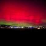 Aurora borealis glows above Park City’s skyline on November 11, casting vivid green and pink hues during a rare geomagnetic storm.