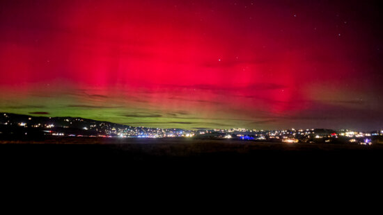 Aurora borealis glows above Park City’s skyline on November 11, casting vivid green and pink hues during a rare geomagnetic storm.