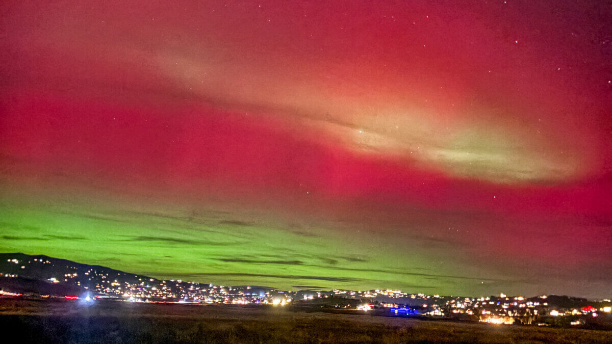 Aurora borealis glows above Park City’s skyline on November 11, casting vivid green and pink hues during a rare geomagnetic storm.