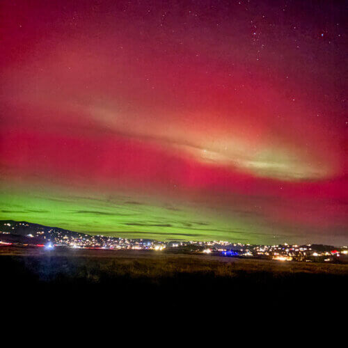 Aurora borealis glows above Park City’s skyline on November 11, casting vivid green and pink hues during a rare geomagnetic storm.