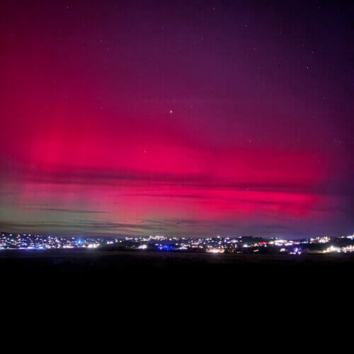 Aurora borealis glows above Park City’s skyline on November 11, casting vivid green and pink hues during a rare geomagnetic storm.
